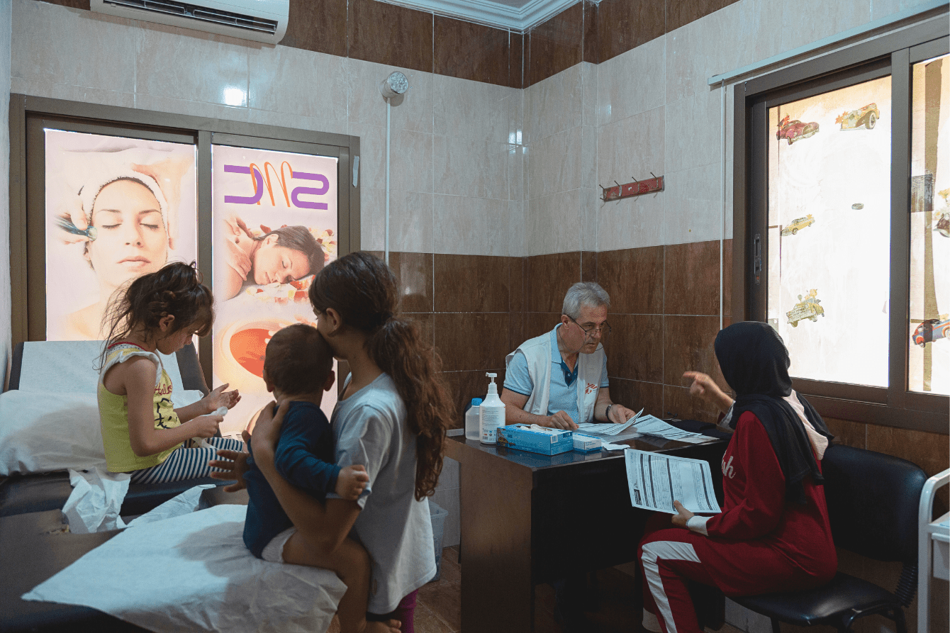 Dr. Ali Daher, from MSF, takes information from Najah as her children wait for her at a clinic in Wadi el Zayni, south of Lebanon.