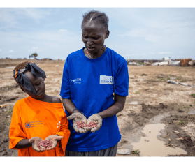 A mother and daughter show in their palms the red bean seeds they are about to plant in the garden plot they are cultivating in Bentiu camp for internally displaced people.